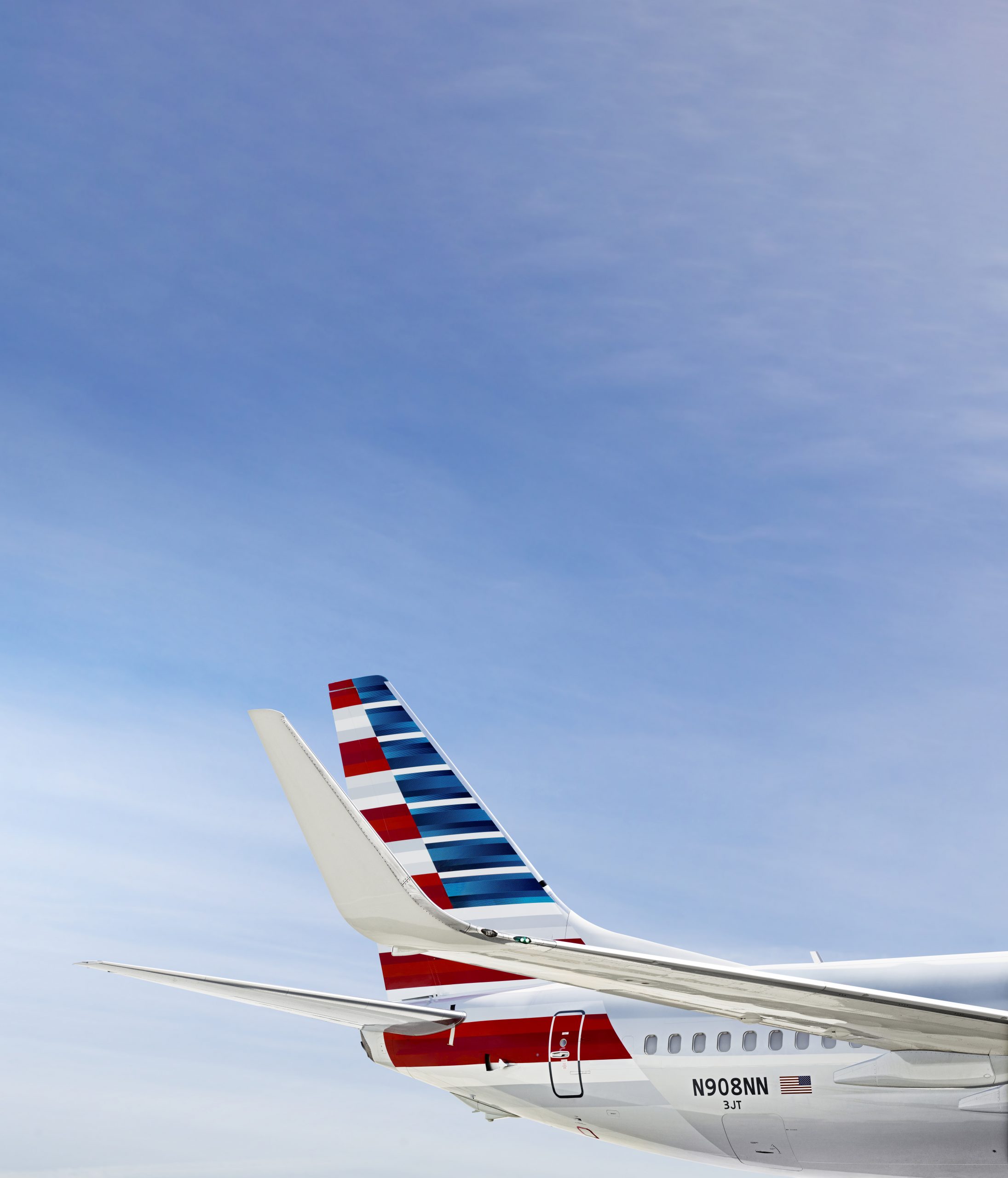 Tail of an American Airlines airplane with a clear blue sky in the background